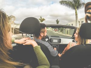 Friends drive in a convertible in Florida.